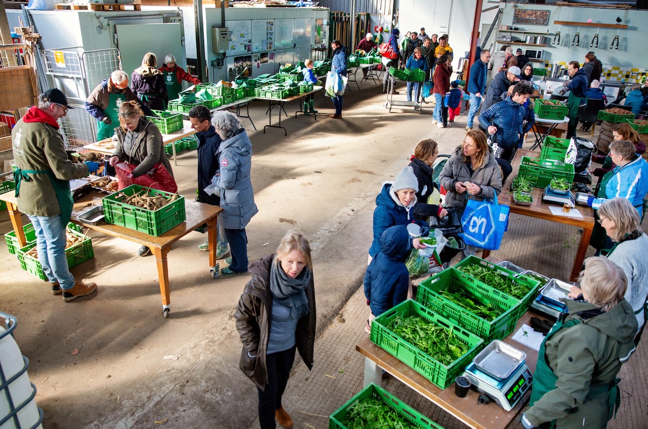 Leden halen tijdens de wekelijkse uitgifte hun verse oogst op bij Herenboeren Heemstede